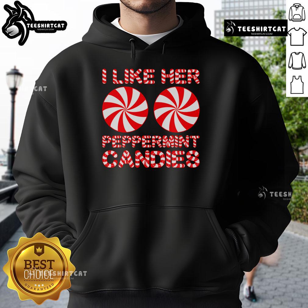 Happy couple in matching 'I Like Her Peppermint Candies' hoodies, celebrating Christmas together in a festive setting.