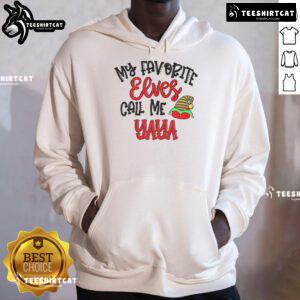 Cozy 'Nice My Favorite Elves Call Me Yaya' hoodie displayed on a rustic wooden background, perfect for holiday wear.