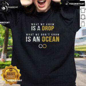 Official sweatshirt featuring the phrase 'What We Know Is A Drop, What We Don't Know Is An Ocean' in stylish design.