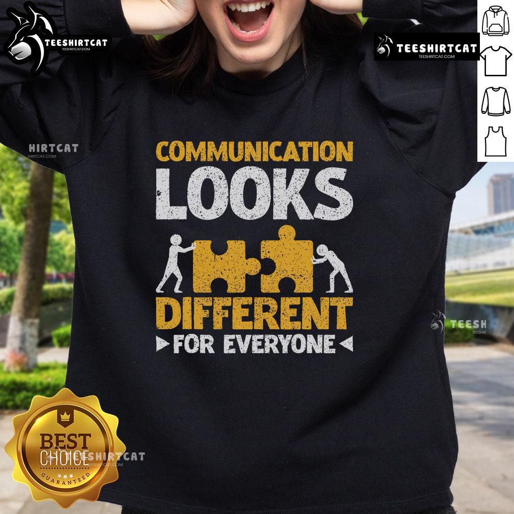 Autism teacher wearing a colorful sweatshirt that says 'Communication Looks Different for Everyone,' promoting inclusivity.