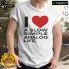 Official I Love A Slow Simple Analog Life T-Shirt displayed on a wooden background, showcasing its unique design and message.