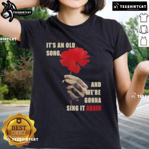 Official Hadestown 'It's an Old Song and We're Gonna Sing It Again' Ladies Tee featuring vibrant artwork and bold text.