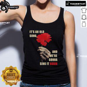 Woman wearing Hadestown 'Old Song' tank top, celebrating the iconic song from the musical in a vibrant setting.