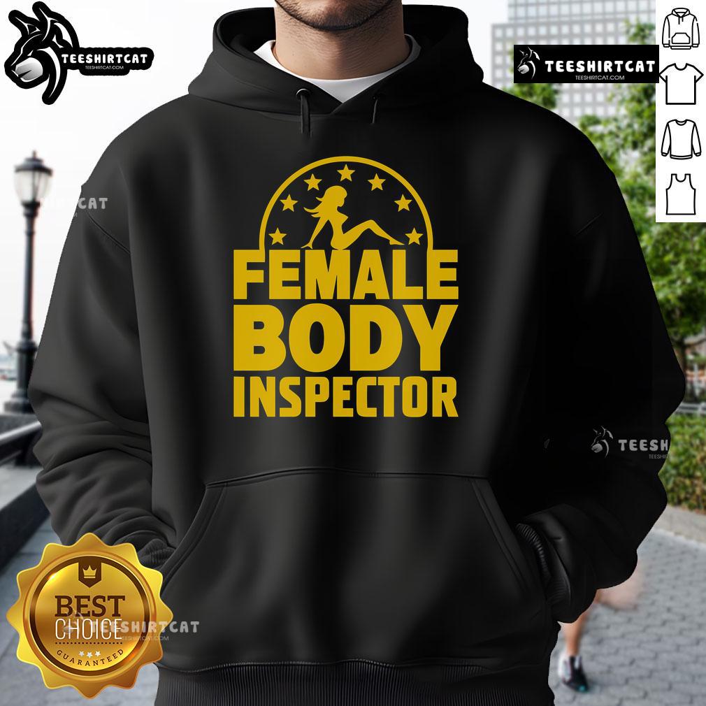 Alt Text: Good Kash Patel wearing a Female Body Inspector hoodie, showcasing a casual and humorous style in a vibrant setting.