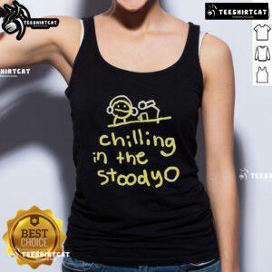 Alt Text: Official Mummy Joe relaxing in the studio, wearing a stylish tank top, exuding cool vibes and creativity.