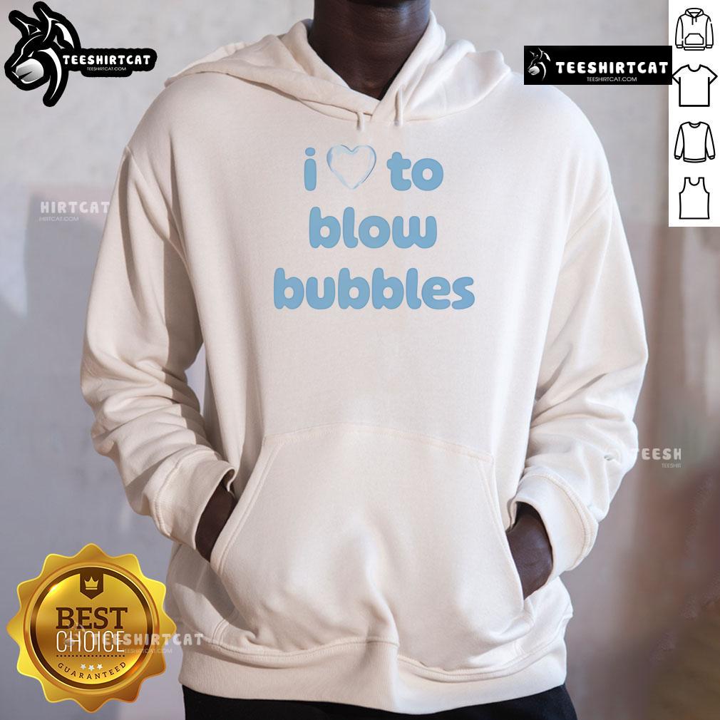 Girl wearing a 'Pretty I Love To Blow Bubbles' hoodie, smiling while blowing colorful bubbles in a sunny park.