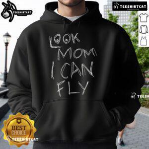 Child in a 'Pretty Look Mom, I Can Fly' hoodie joyfully jumping against a bright blue sky, showcasing playful spirit.