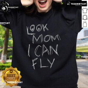 Child wearing a 'Pretty Look Mom I Can Fly' sweatshirt, smiling joyfully outdoors, showcasing playful style and comfort.
