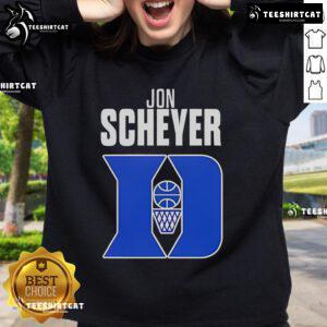 Jon Scheyer wearing a Duke Blue Devils Coach of the Year sweatshirt during a basketball game celebration.