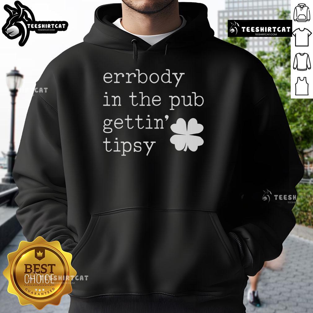 Group of friends wearing St. Patrick's Day hoodies enjoying drinks and celebrations in a lively pub atmosphere.