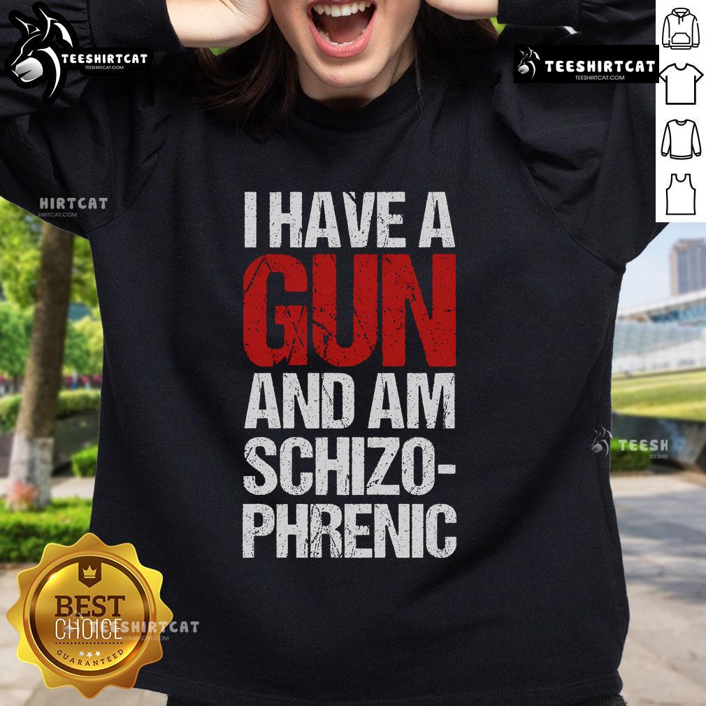 Person wearing a 'I Have A Gun And Am Schizophrenic' sweatshirt, showcasing bold text design and casual style.