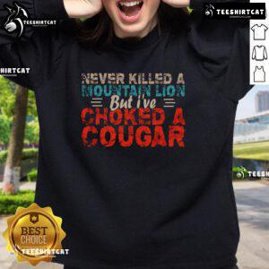 Funny Never Killed A Mountain Lion But I've Choked A Cougar Sweatshirt design featuring a humorous graphic and bold text.