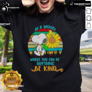 Happy Snoopy with sunflowers on a retro sweatshirt featuring 'Be Kind' quote, perfect for casual wear and dog lovers.