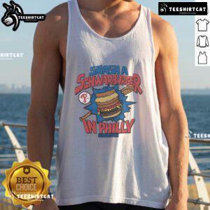Philadelphia Phillies fan wearing a Good MLB X Flavortown tank top while enjoying a Schwarburger in Philly.