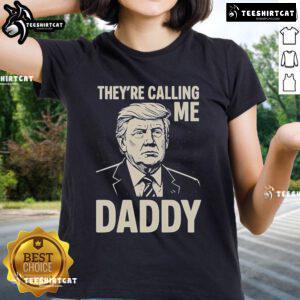 Alt Text: Official Trump 'They're Calling Me Daddy' Ladies Tee featuring bold graphics on a stylish women's shirt.