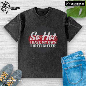 Official 'So Hot I Have My Own Firefighter' washed t-shirt displayed on a hanger, showcasing fire-themed graphic design.