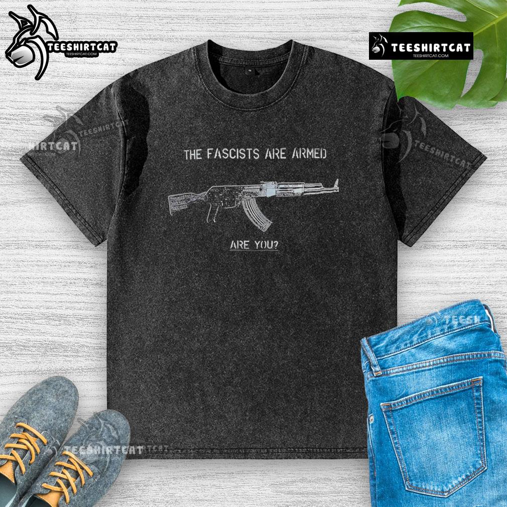 Top The Fascists Are Armed Are You washed t-shirt design featuring bold text on a stylish cotton fabric.