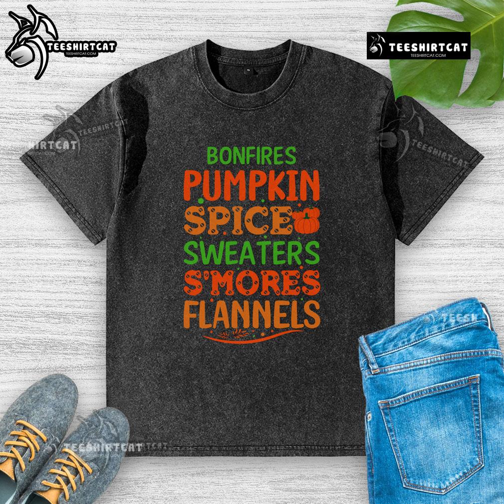 Cozy scene with pretty bonfires, pumpkin spice, sweaters, s'mores, and flannels on a washed t-shirt background.