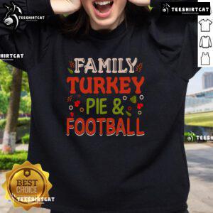 Pretty family wearing turkey pie and football sweatshirts, celebrating Thanksgiving together in a cozy living room.