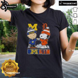 Cute Snoopy and Charlie Brown in Michigan sports gear, featuring Wolverines and Detroit Tigers skyline on ladies tee.