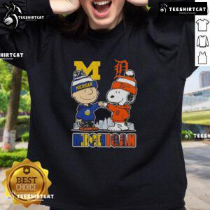 Cute Snoopy and Charlie Brown Michigan Sports sweatshirt featuring Wolverines and Detroit Tigers skyline design.