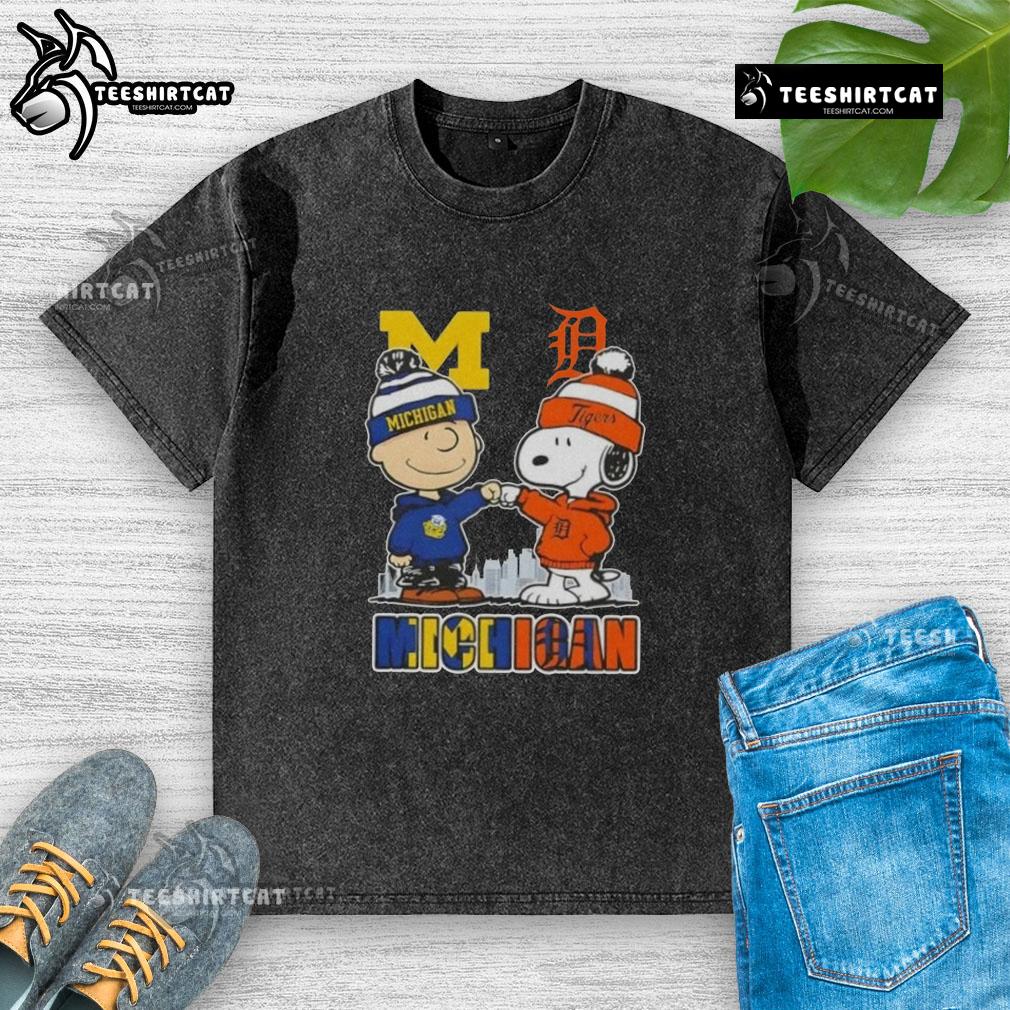 Cute Snoopy and Charlie Brown in Michigan sports Wolverines and Detroit Tigers skyline washed t-shirt design.