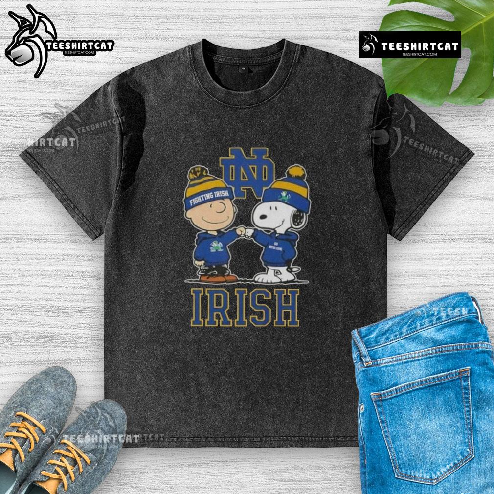Alt Text: Cute Snoopy and Charlie Brown Notre Dame Fighting Irish football skyline washed t-shirt design featuring iconic characters.
