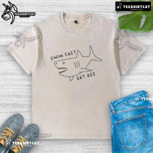 Funny Swim Fast Eat Ass Shark Washed T-Shirt featuring a playful shark graphic and humorous text, perfect for beachwear.