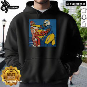 Good Teair Tart slapping Travis Kelce wearing a stylish hoodie, capturing a fun and playful moment.