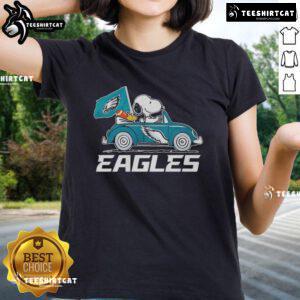 Alt Text: Philadelphia Eagles flag featuring Snoopy and Woodstock driving a car on a ladies tee, perfect for fans.