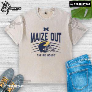 Alt Text: Official Michigan Wolverines maize out scratch helmet washed T-shirt displayed on a wooden background.