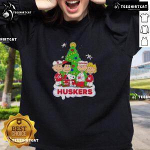 Alt Text: Good Peanuts characters Christmas sweatshirt featuring Nebraska Cornhuskers design, perfect for holiday cheer.