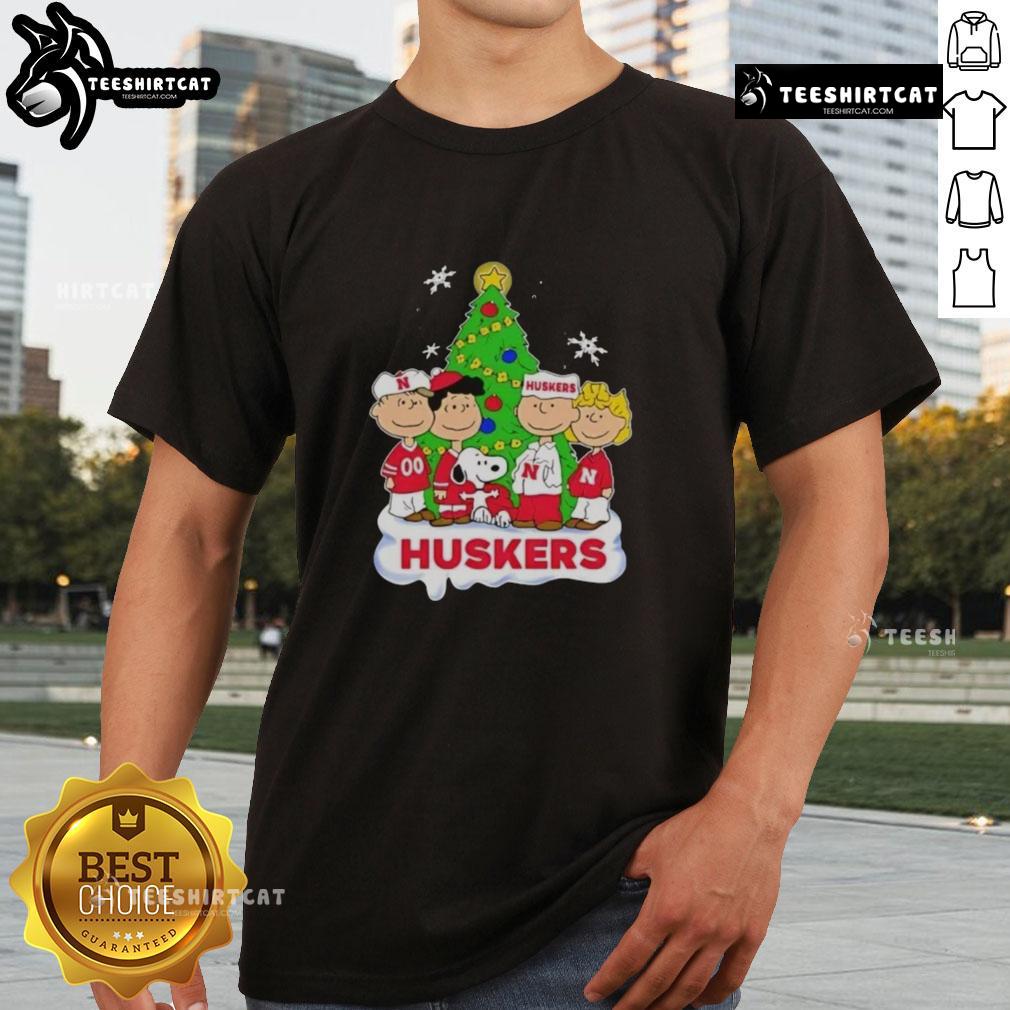Good Peanuts Characters Christmas T-Shirt featuring Nebraska Cornhuskers logo, perfect for holiday sports fans.