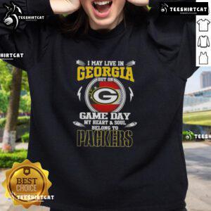 Official I May Live In Georgia But On Game Day My Heart And Soul Belongs To Green Bay Packers Sweatshirt displayed.