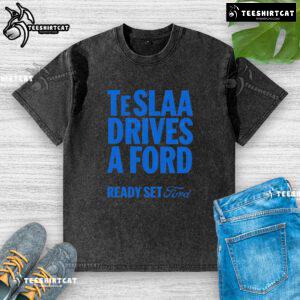 Alt Text: Top Tesla drives a Ford in a 'Ready Set Ford' washed t-shirt, showcasing a fun automotive twist and style.