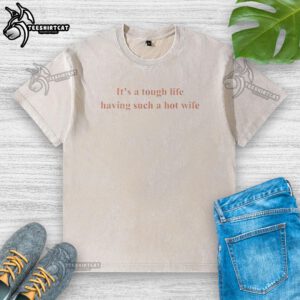 Awesome 'It's a Tough Life Having Such a Hot Wife' washed t-shirt displayed on a rustic wooden background.