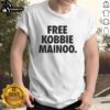 Happy Man United fan wearing a 'Free Kobbie Mainoo' t-shirt, celebrating his brother Kobbie Mainoo's impact in football.