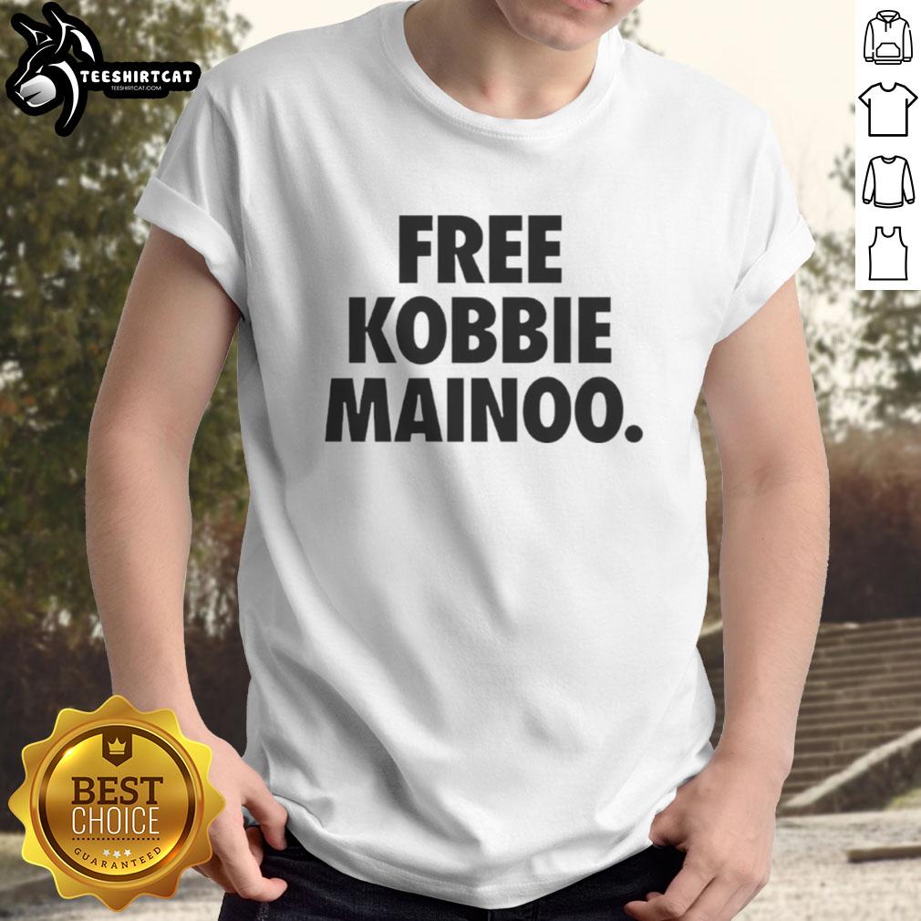 Happy Man United fan wearing a 'Free Kobbie Mainoo' t-shirt, celebrating his brother Kobbie Mainoo's impact in football.