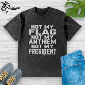Premium Not My Flag Not My Anthem Not My President washed t-shirt displayed on a wooden surface, showcasing its unique design.