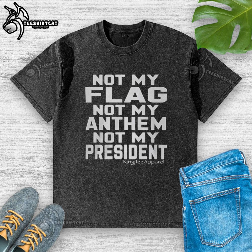 Premium Not My Flag Not My Anthem Not My President washed t-shirt displayed on a wooden surface, showcasing its unique design.
