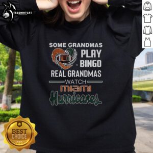 Premium sweatshirt featuring grandmas playing bingo while watching Miami Hurricanes game, perfect for sports fans.
