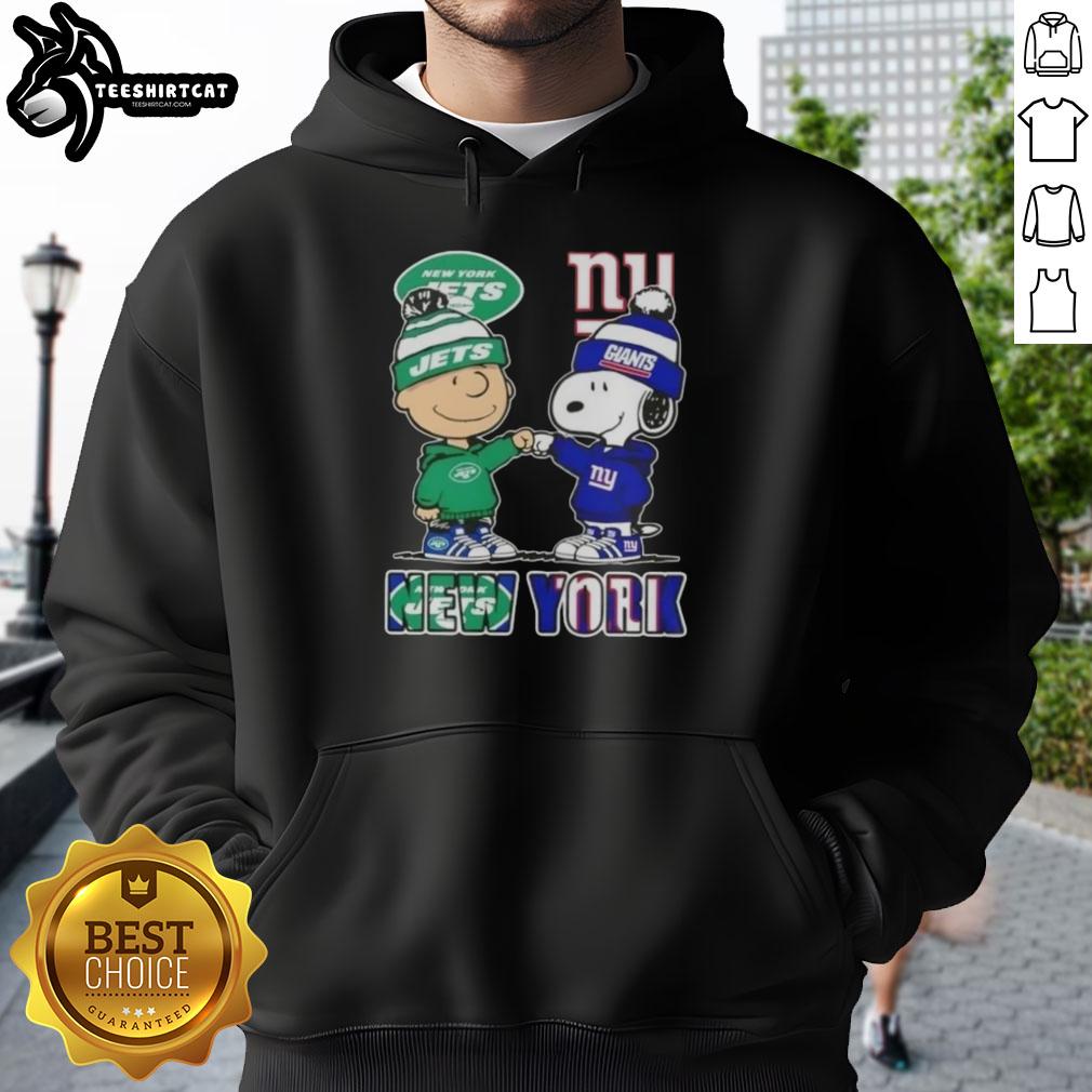Pretty Charlie Brown fist bump with Snoopy in New York City, wearing Jets x Giants hoodie, celebrating sports spirit.