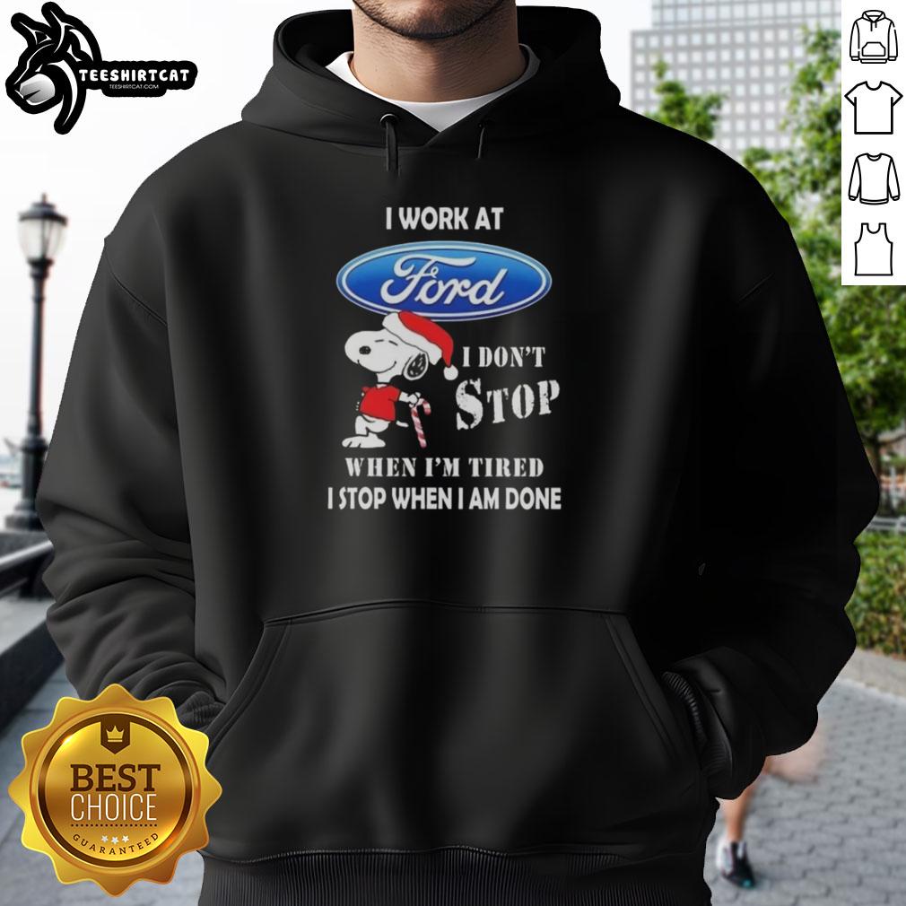 Snoopy Christmas hoodie with 'I work at Ford Motor, I don't stop when I'm tired, I stop when I'm done' design.