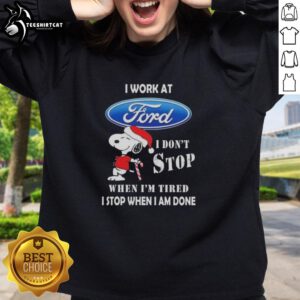 Cozy Christmas sweatshirt featuring Snoopy and 'I Work At Ford Motor, I Dont Stop When Im Tired' slogan.