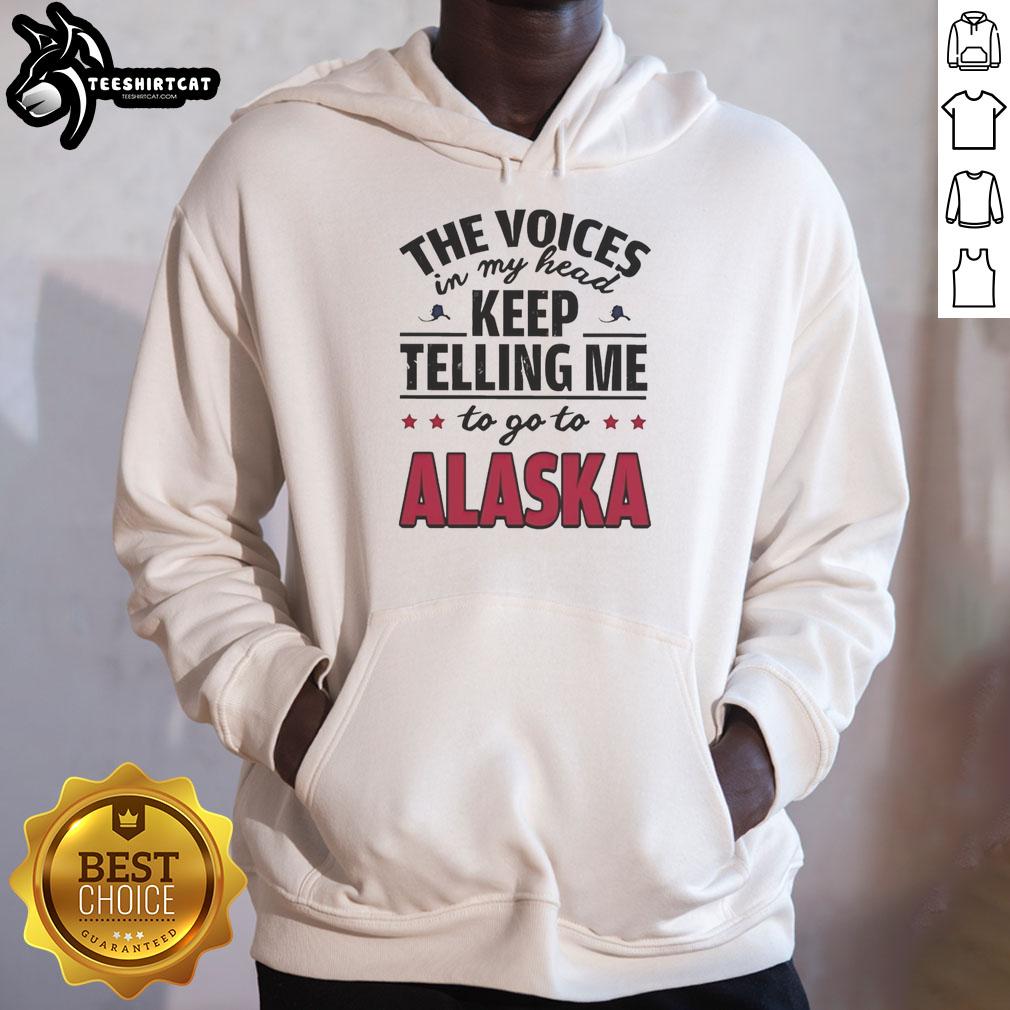 Nice hoodie with the phrase 'The Voices In My Head Keep Telling Me To Go To Alaska' printed on it, perfect for cozy wear.