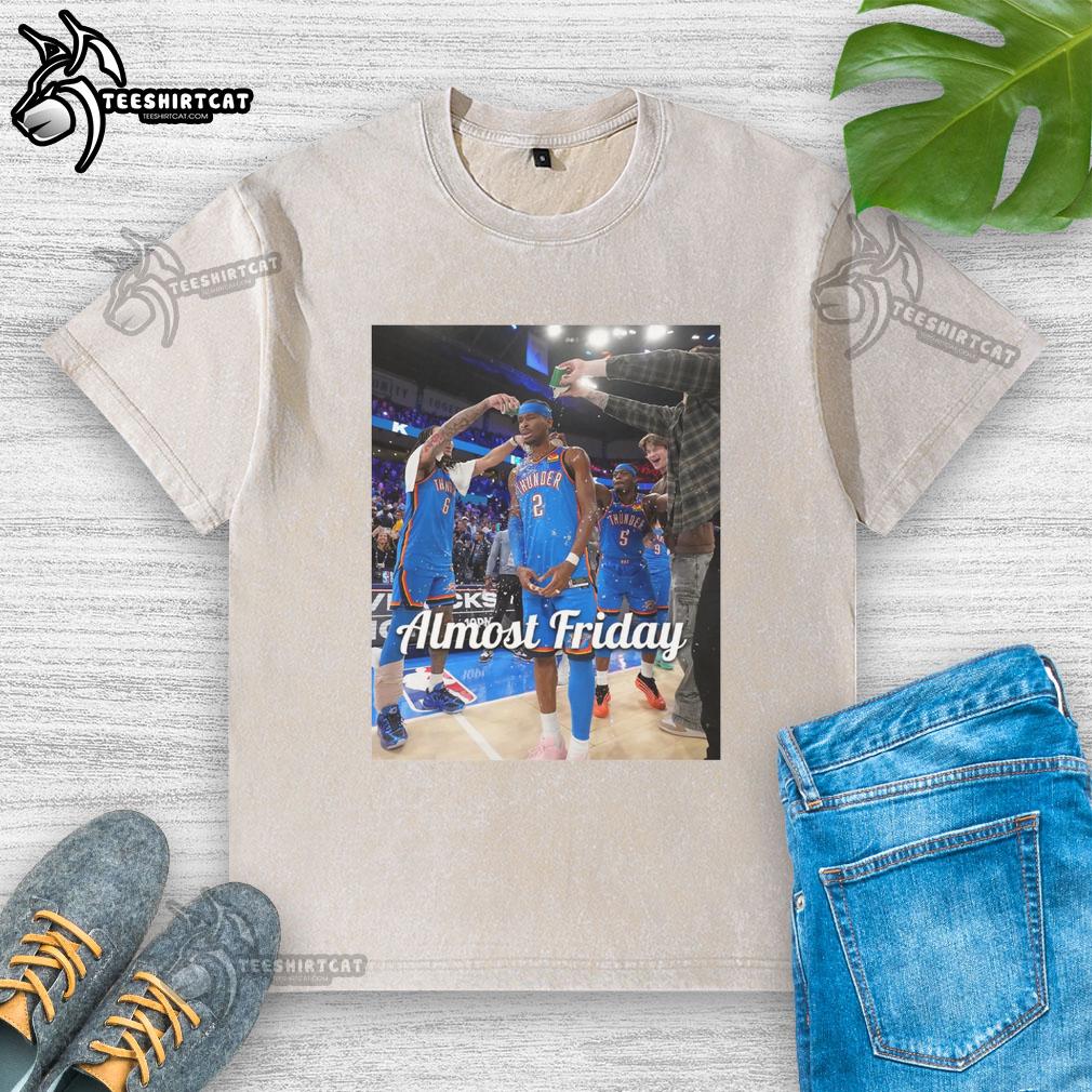 Shai Gilgeous-Alexander in an Oklahoma City Thunder 'Almost Friday' postgame washed t-shirt, showcasing team spirit.