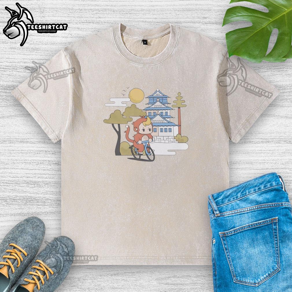 Cute monkey riding a bicycle in a washed t-shirt, showcasing a playful scene of adventure and fun outdoors.